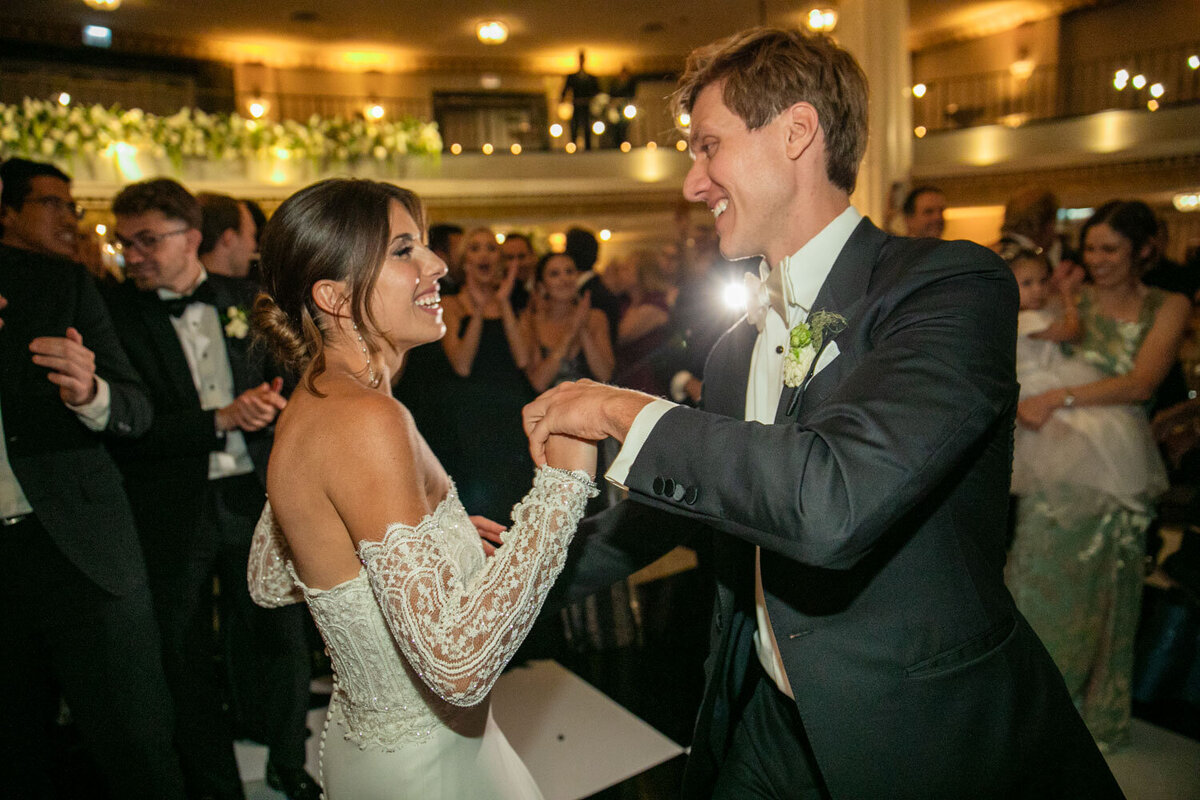A bride and groom are dancing at their wedding reception