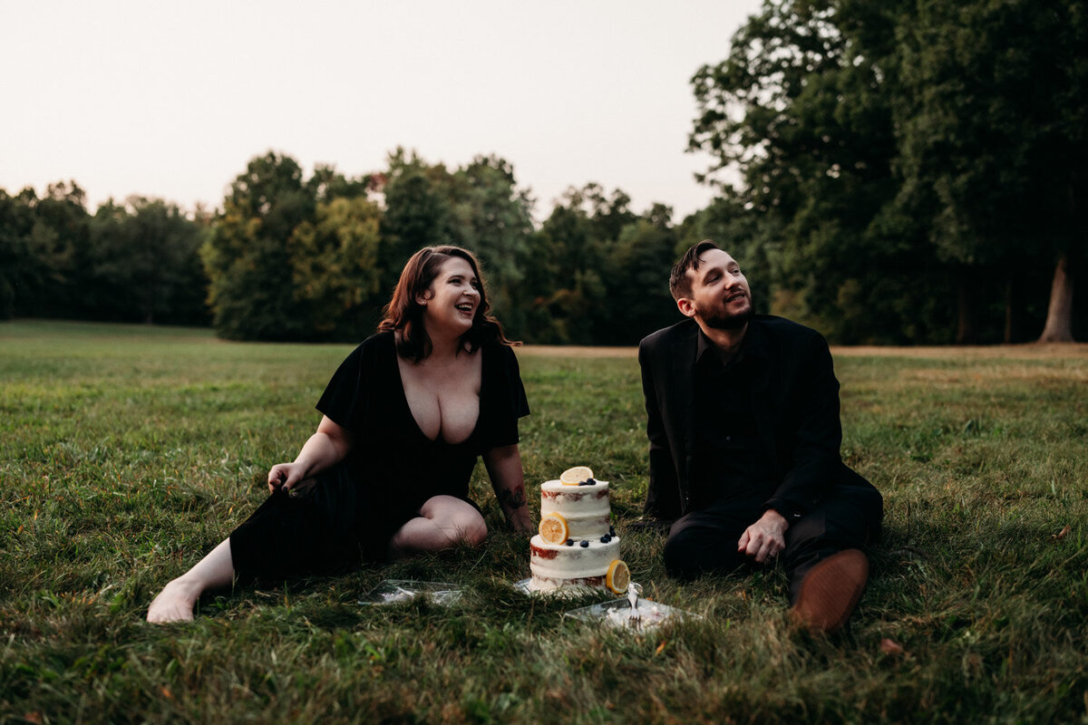 Newlyweds share cake in grass of national park