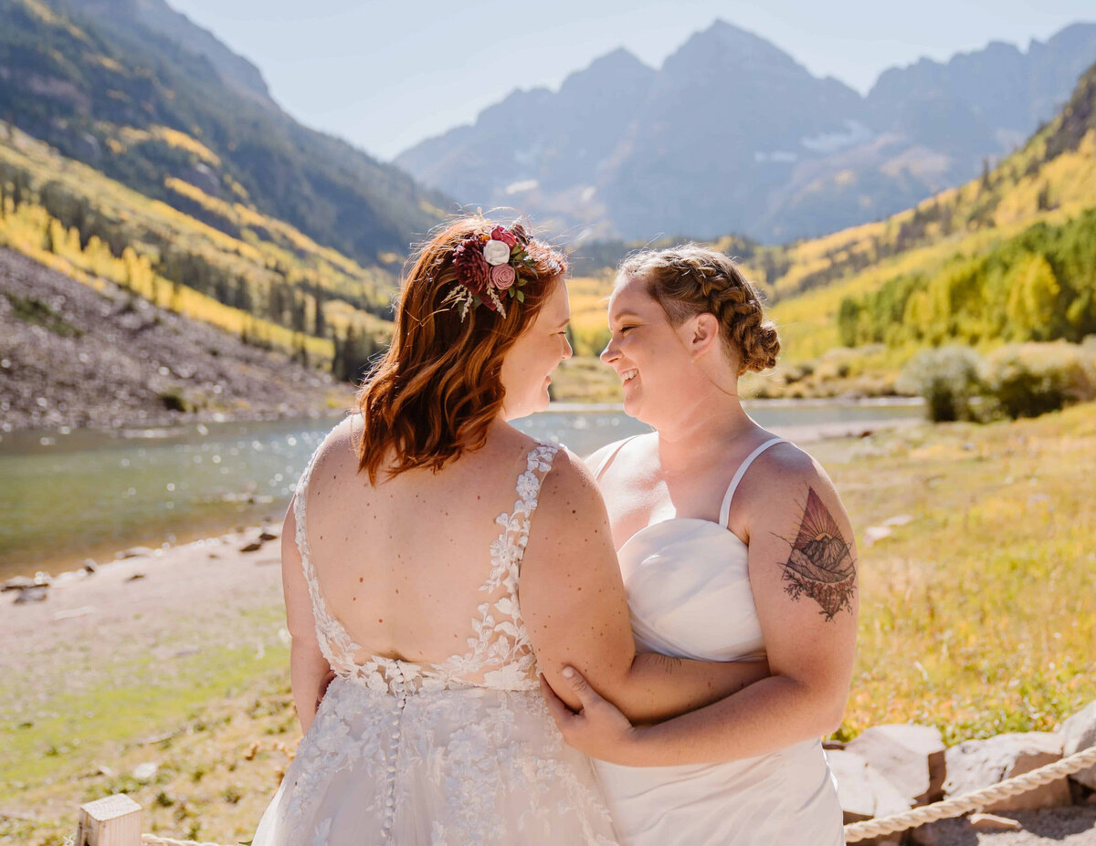 Lesbian couple exchanges vows with the iconic Maroon Bells peaks in the background at Maroon Bells Amphitheater, Colorado.