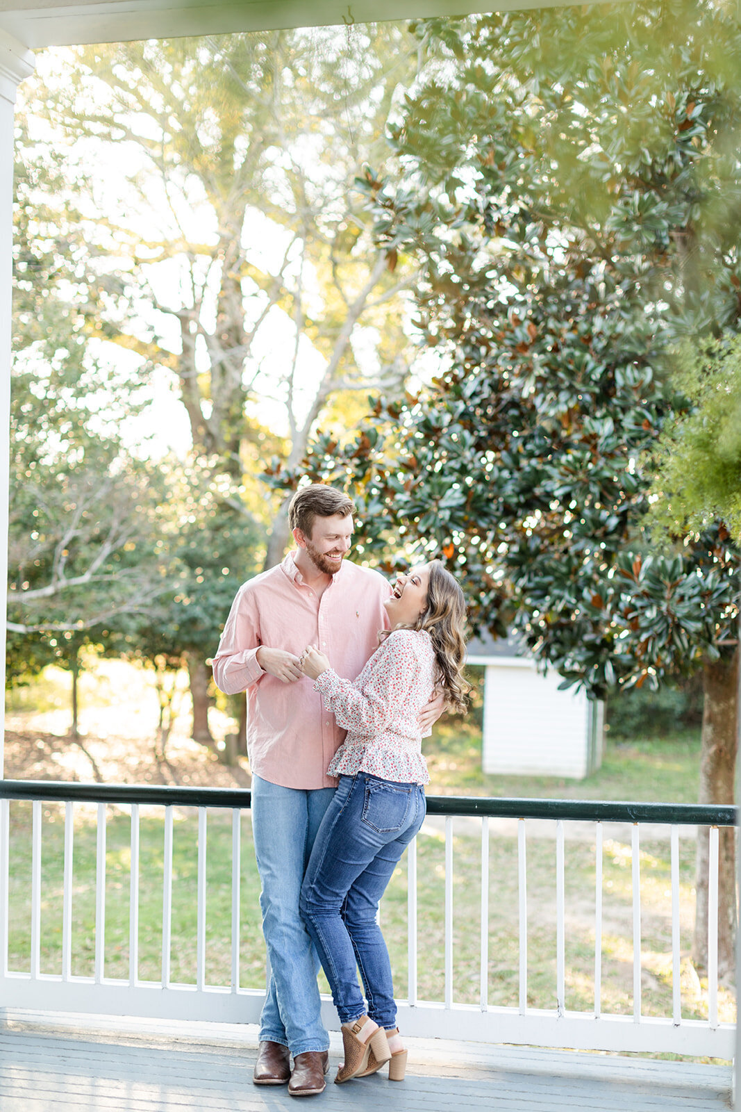 Engagement portrait of couple laughing on porch at Springhill College, Mobile, Alabama