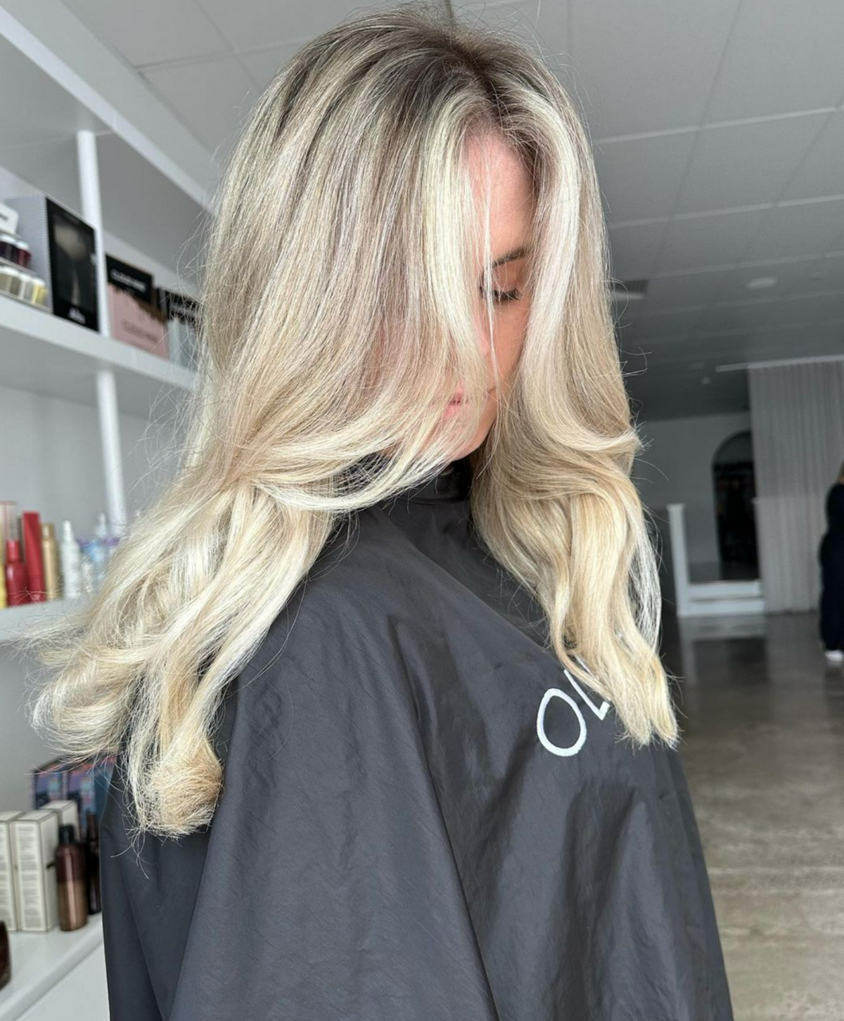 Girl in hairdressers cape with long blonde hair