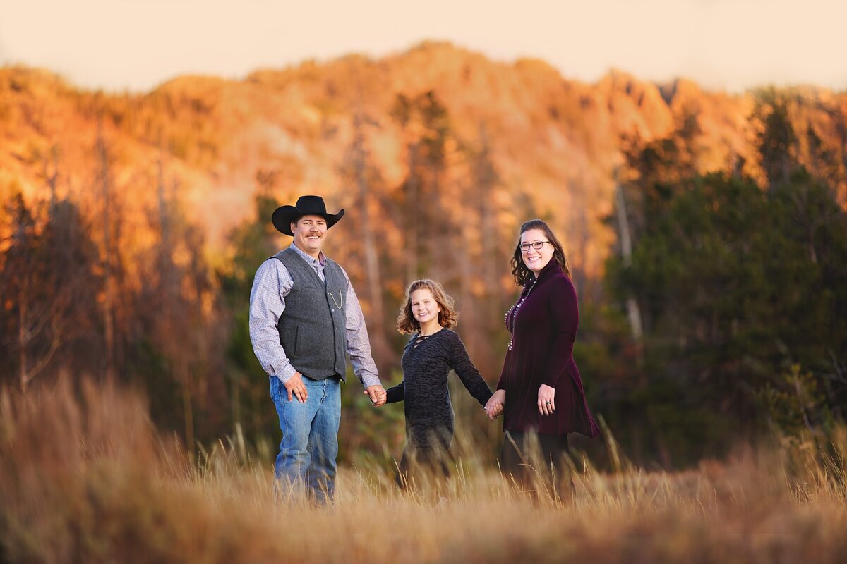Beautiful family in the mountains by Happy Jack wearing a cowboy hat and dresses at sunset.