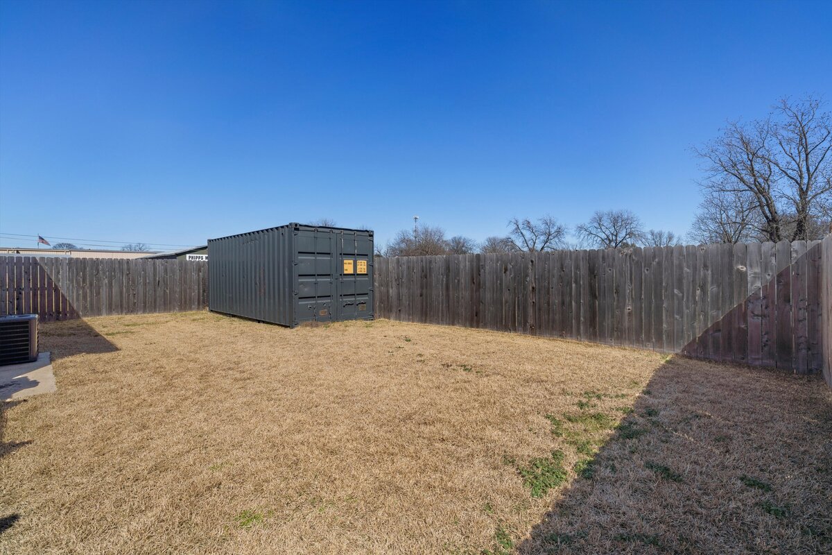 Fenced-in backyard at this one-bedroom, one-bathroom vacation rental condo with free Wifi, free parking, and extra twin bed in downtown Waco, TX.