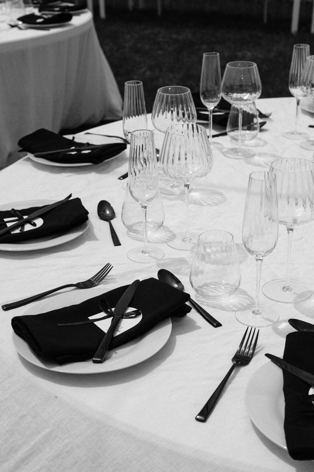 elegant black napkins with ribbed glassware on a wedding table setting in a clear marquee in christchurch