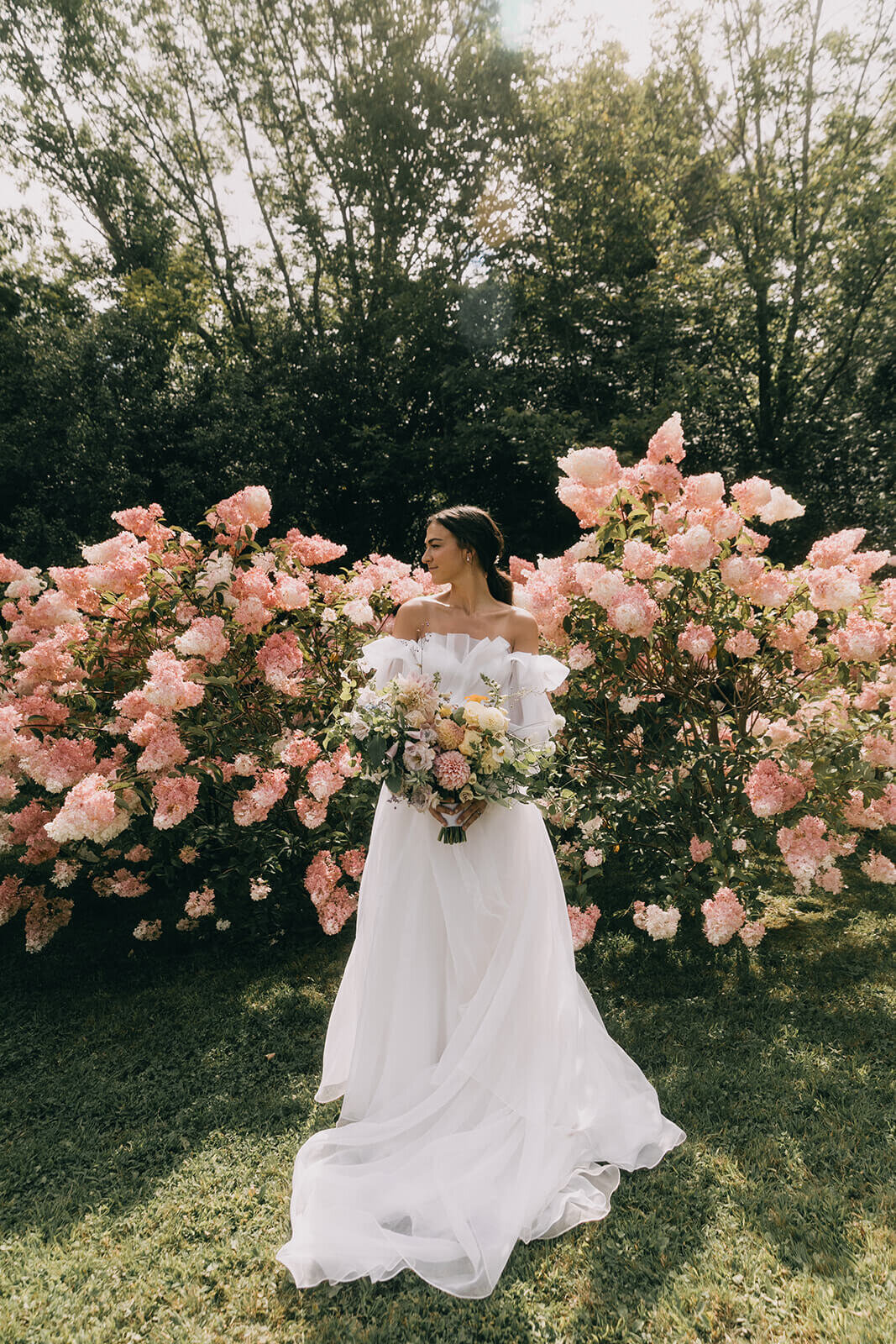 17.bride-holding-bouquet-walking-through-pink-hydrangeas