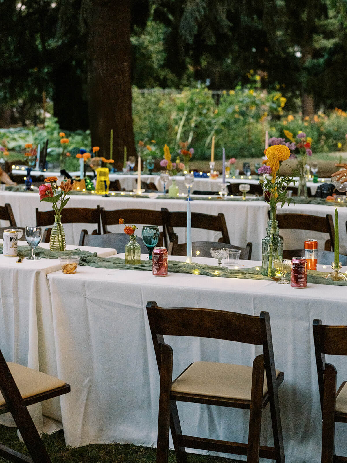 Outdoor reception for a wedding all set up with flowers, linens and place settings. 