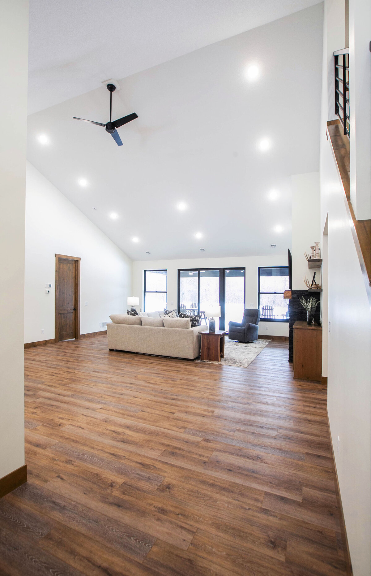 Cozy living room in Elk River custom home with fireplace, built-ins, and large windows