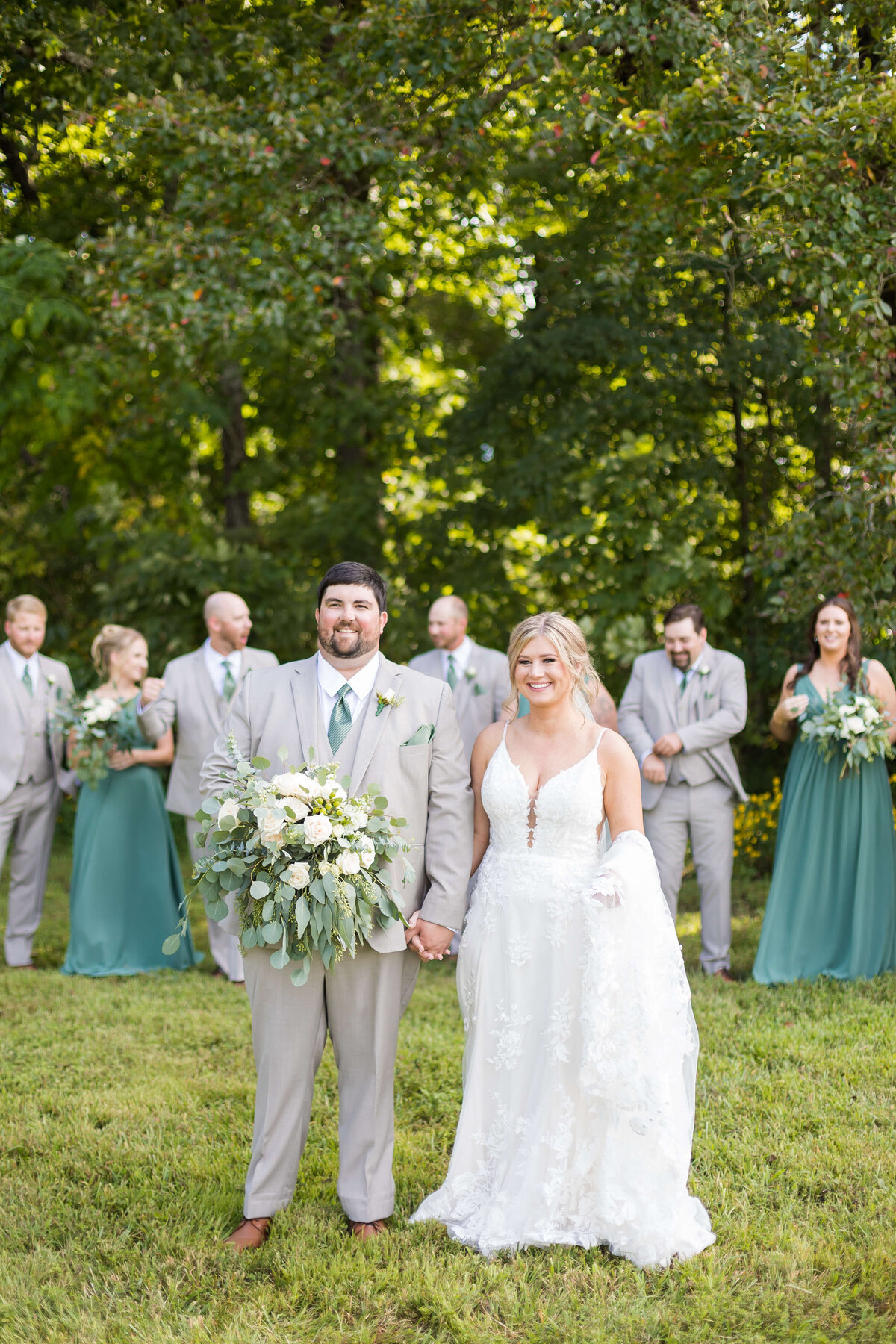 Bride and groom with wedding party standing behind them at  The Barn at White Oaks, Murray, Kentucky