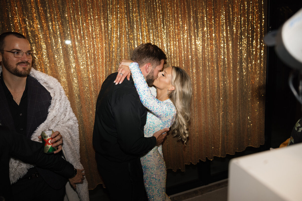 bride and groom kiss at party