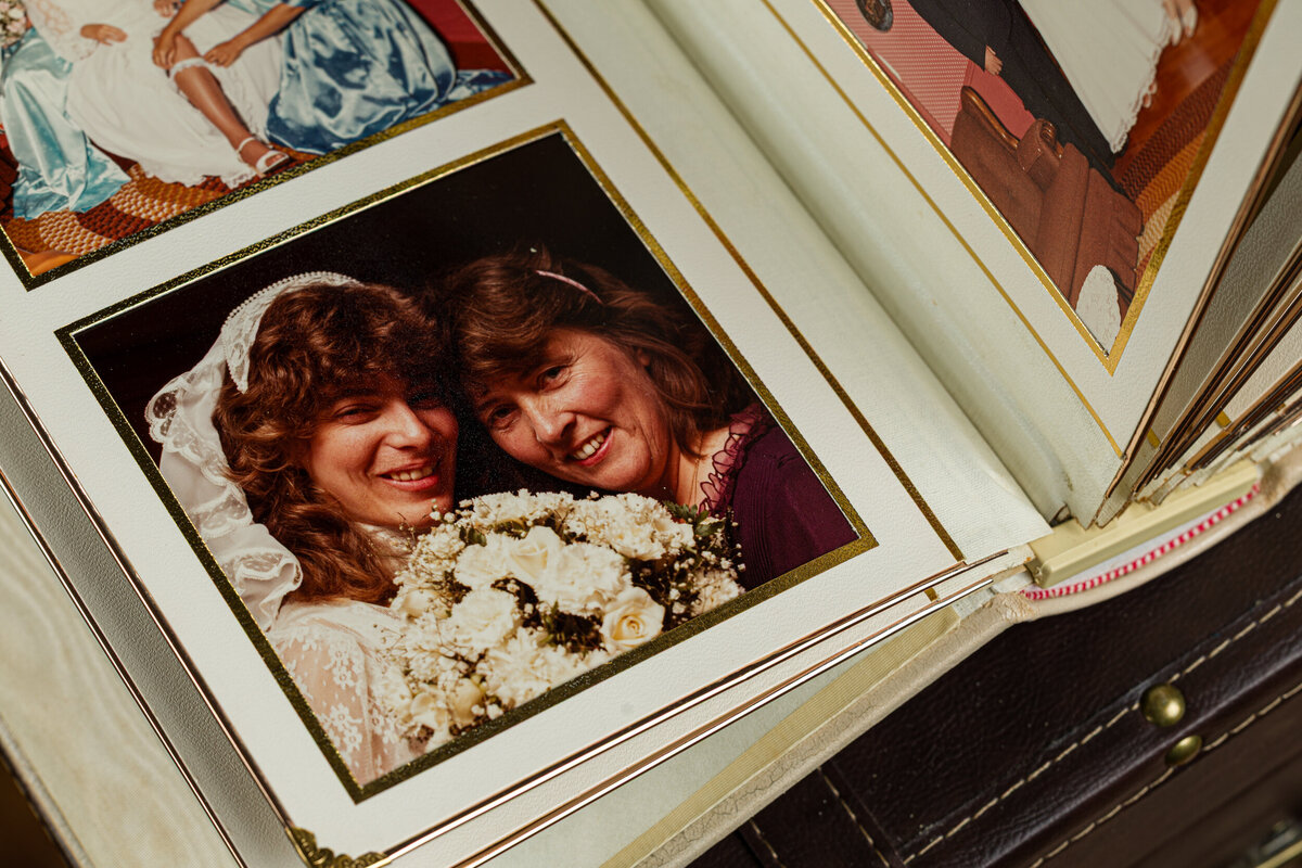 An open old wedding album showing square photos in slide-in pages, capturing timeless memories.