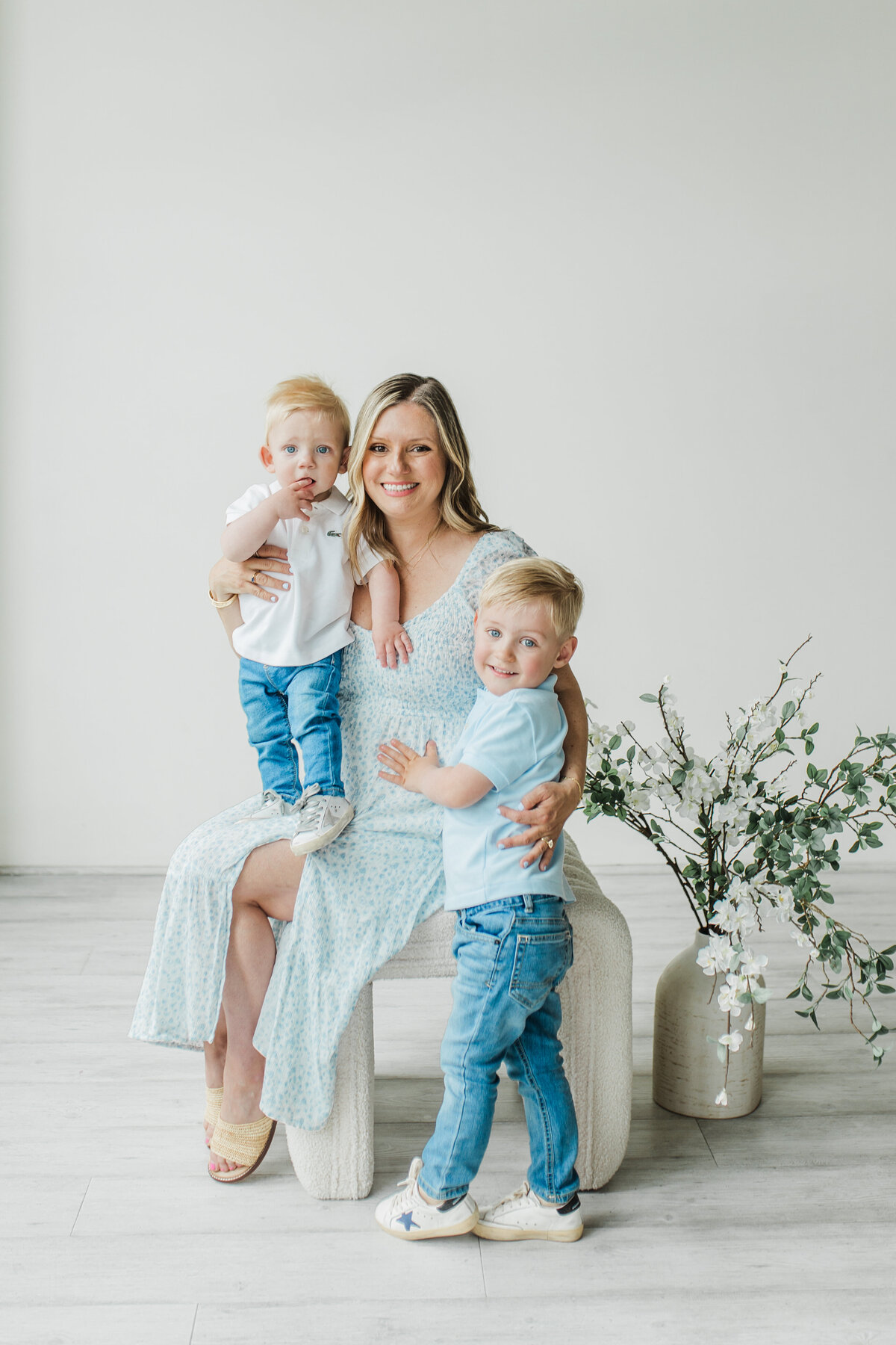 Mother sitting with two young children in a bright room