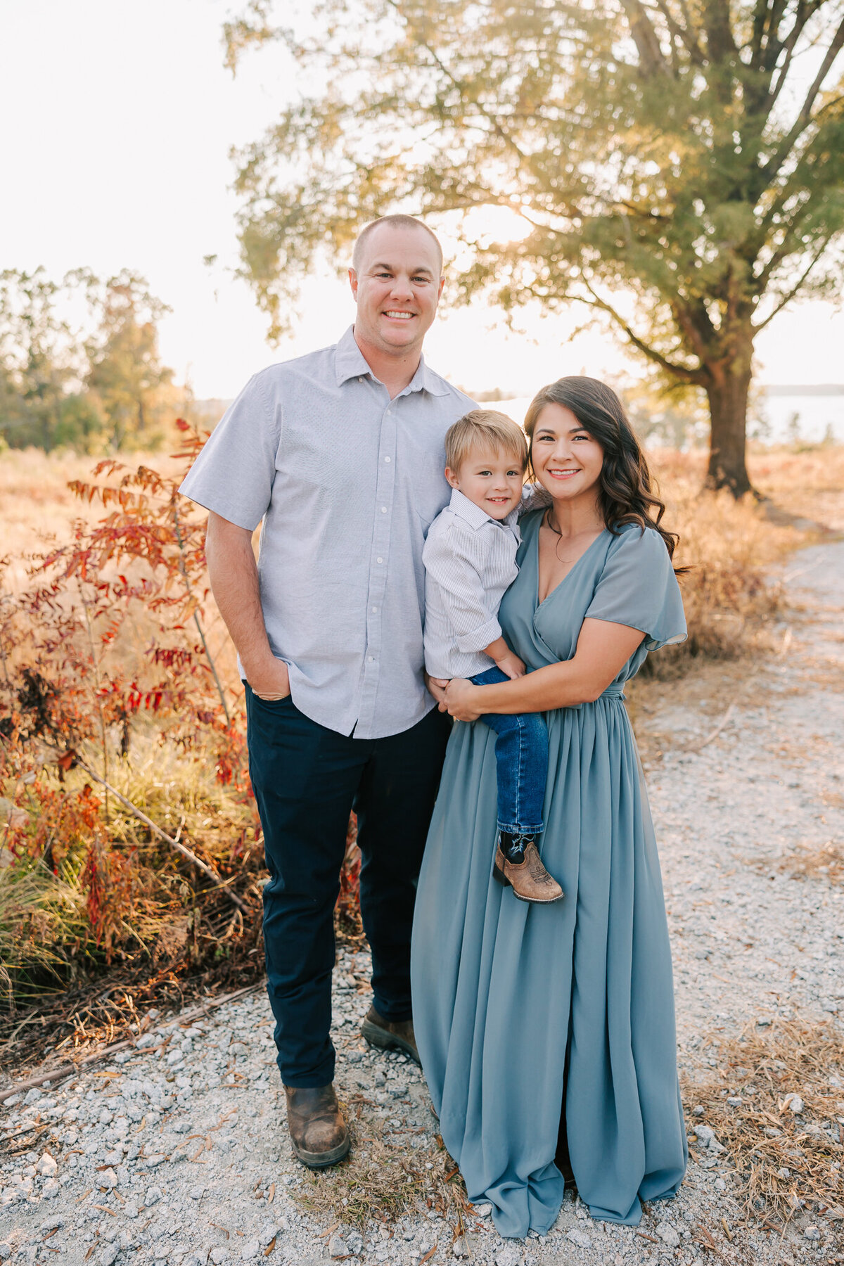 Mom dad and three year old sharing a smile during their session. mom and son are wearing client clsoet from molly berry photography