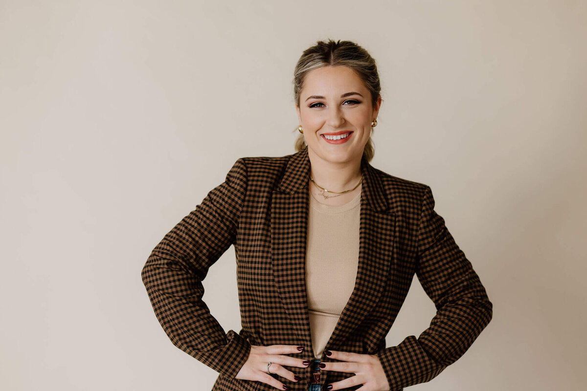 fun candid headshot of graduate in neutral colors and brown blazer