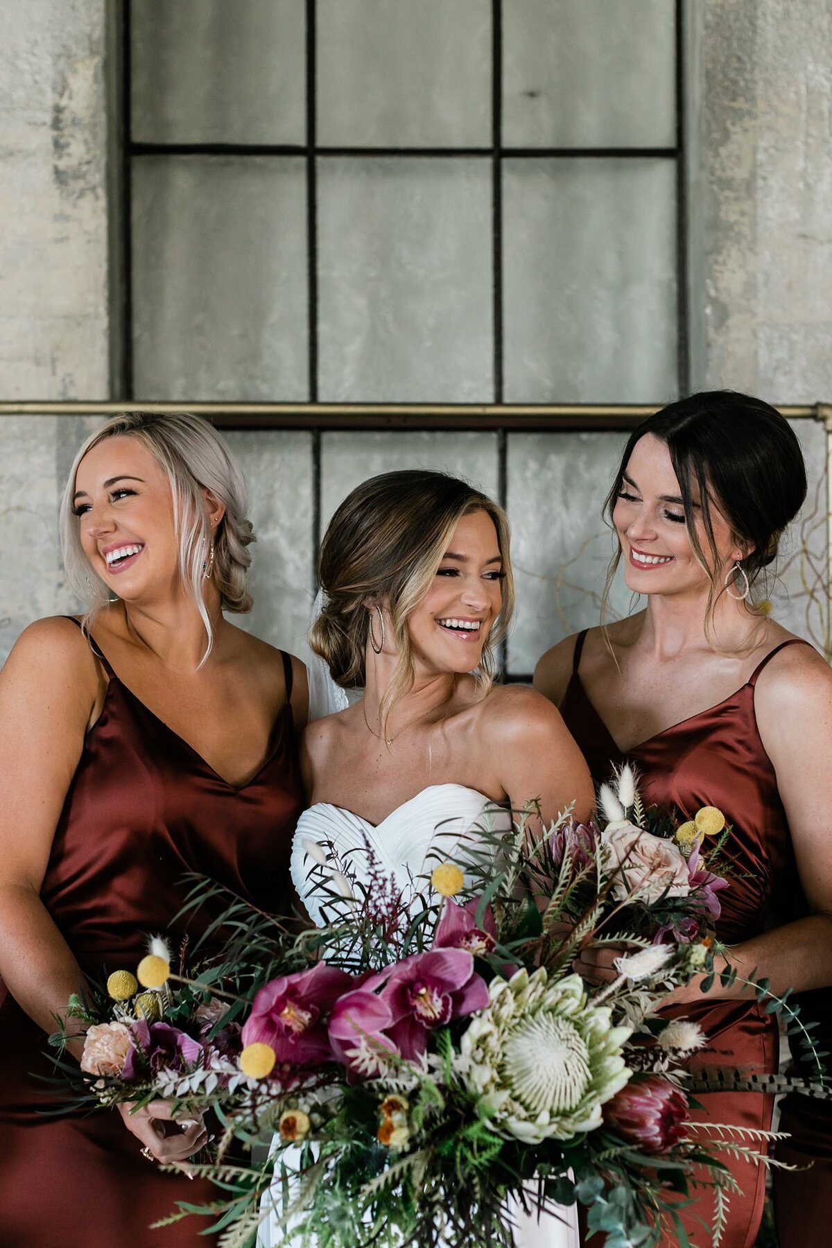 Bride smiling and laughing with her bridesmaids in the chapel at Olde Dobbin Station.