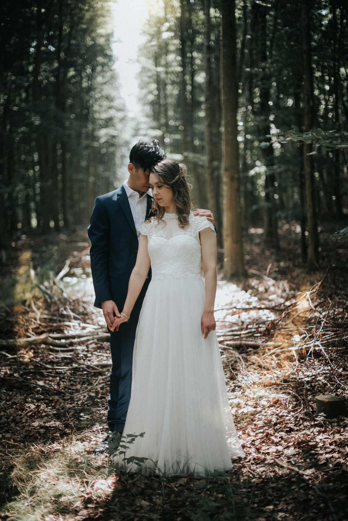 Bride and groom standing in the woods