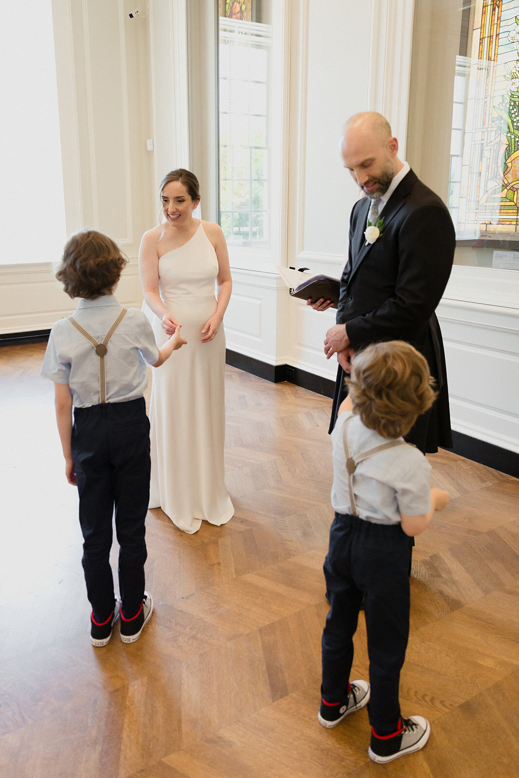 The little ring bearers hand the wedding rings to the couple.
