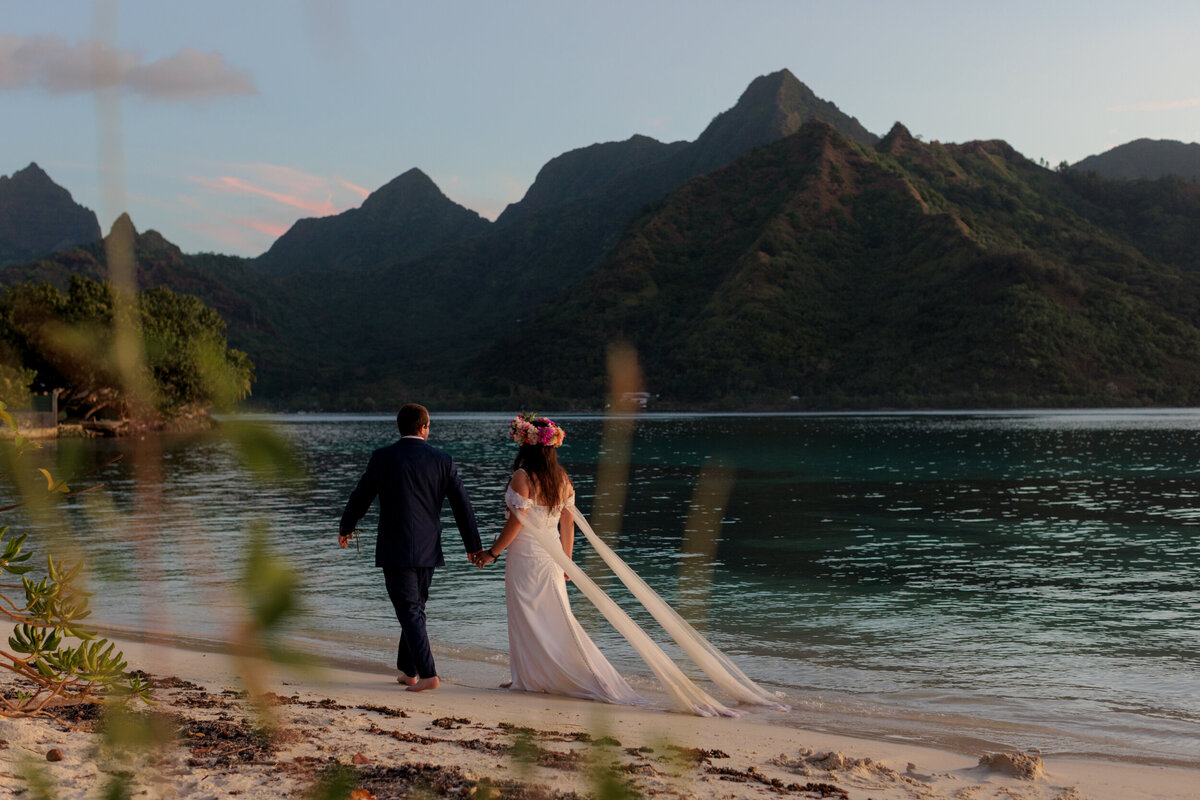 bride-and-groom-walk-beach-at-sunset-on-tropical-island