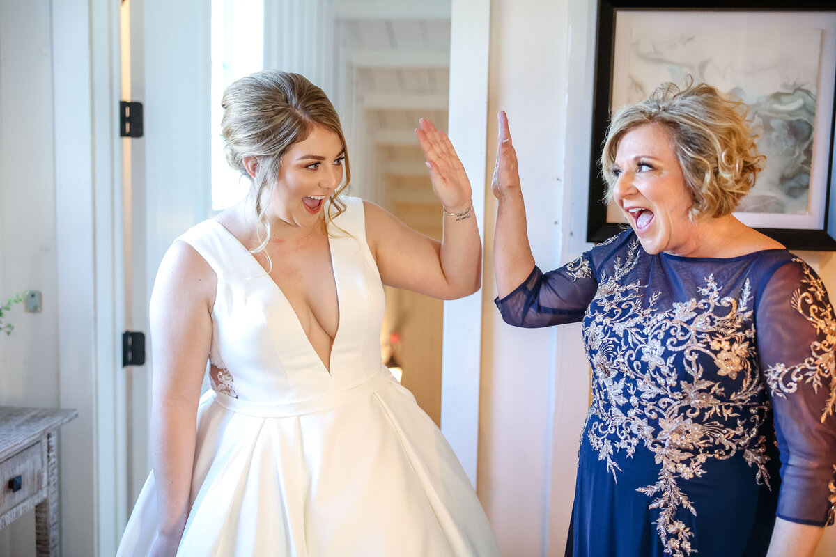 mother of bride in navy dress gives daughter high five at wedding in Austin Texas