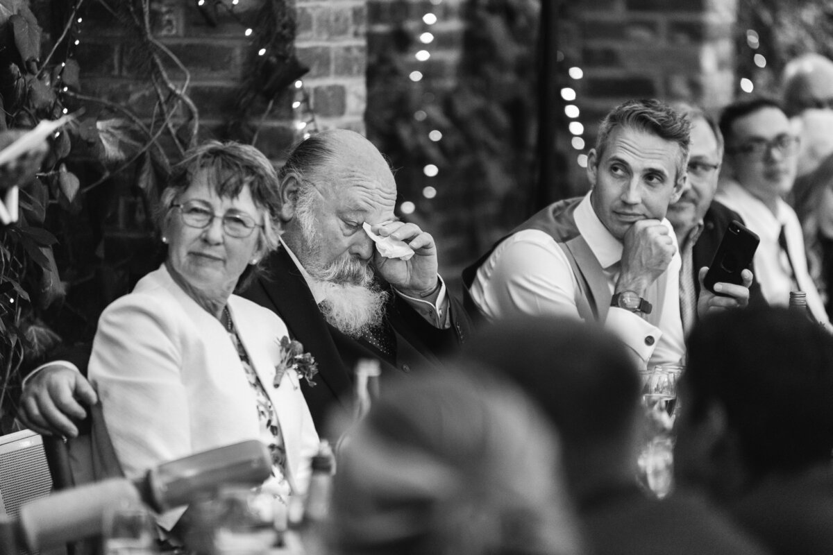 father of the groom crying in candid photo of wedding