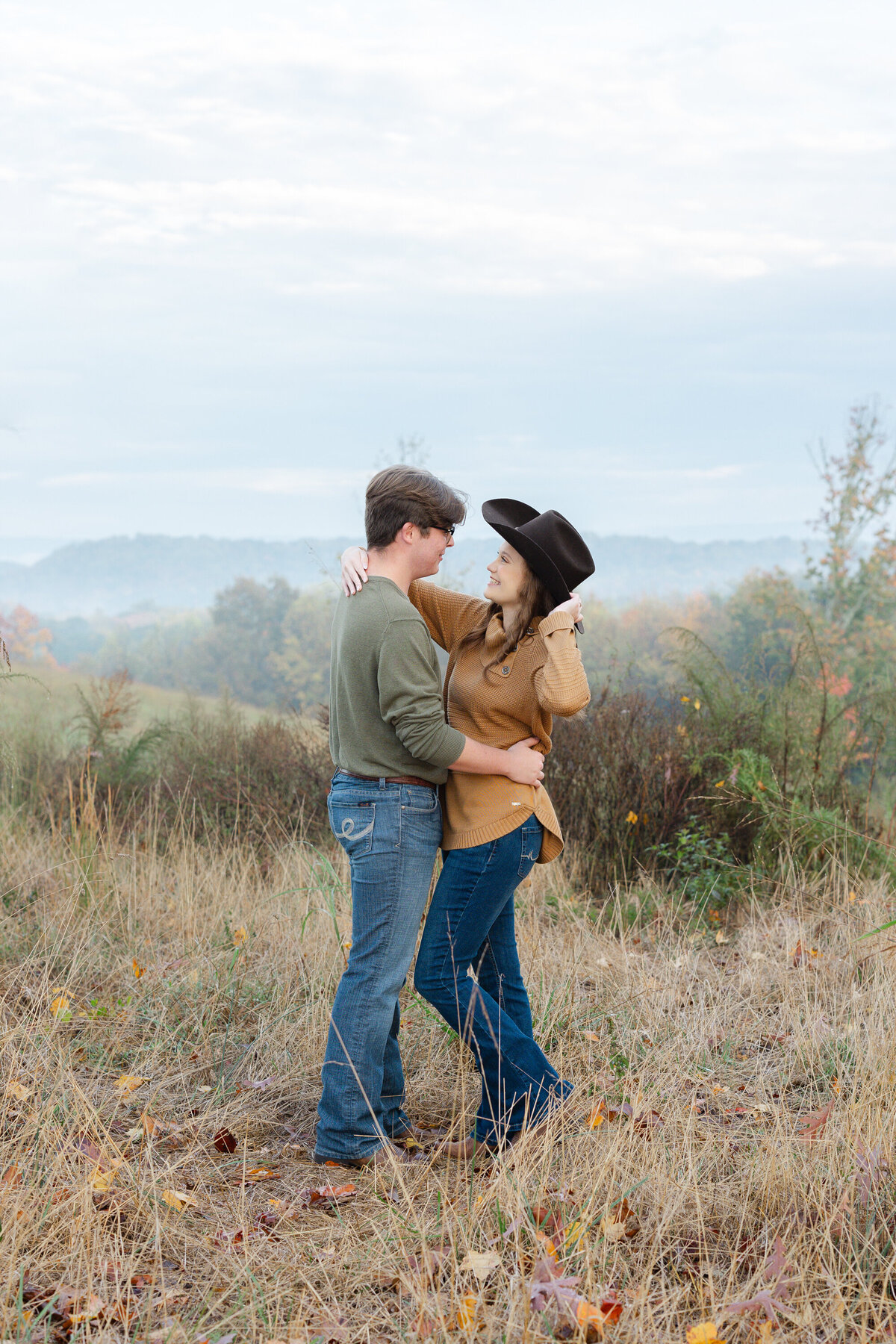 couple posing in a field overlooking mountains in Cleveland, TN
