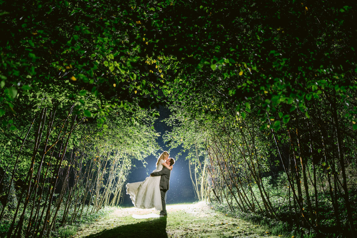 creative wedding photography taken at night of bride and groom kissing