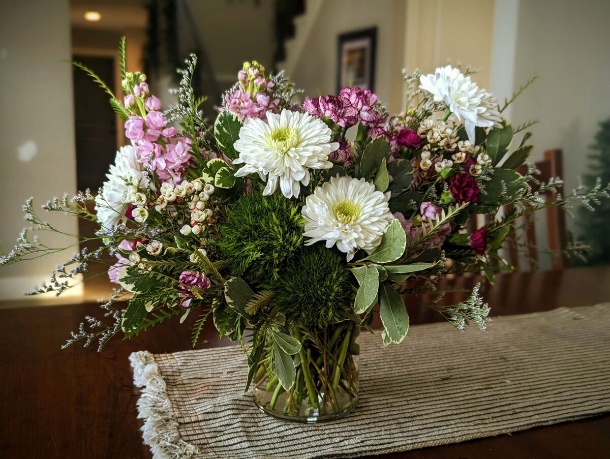 white funeral flowers with purple and pink in vase 3