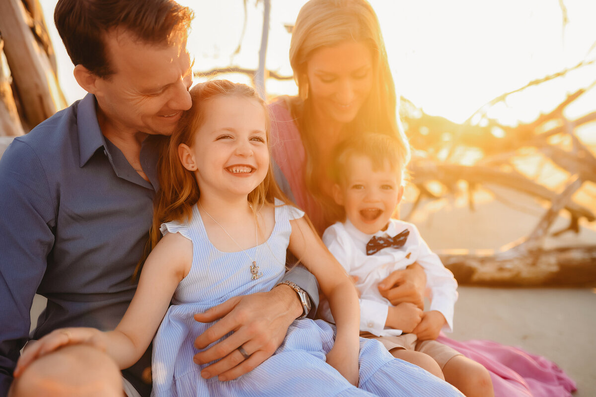 Parents embrace their children during Family Photoshoot on Folly Beach. 