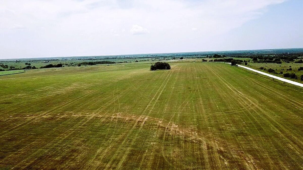 Aerial view of 11-acre property in Lindsay, Texas with open fields and clear skies