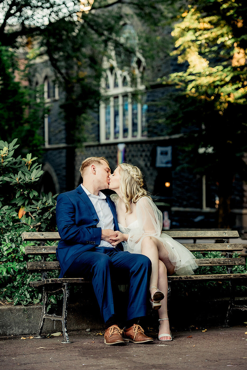 couple kissing on park bench