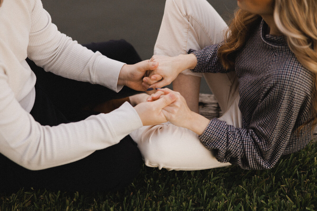 Couple sitting cross legged holding hands