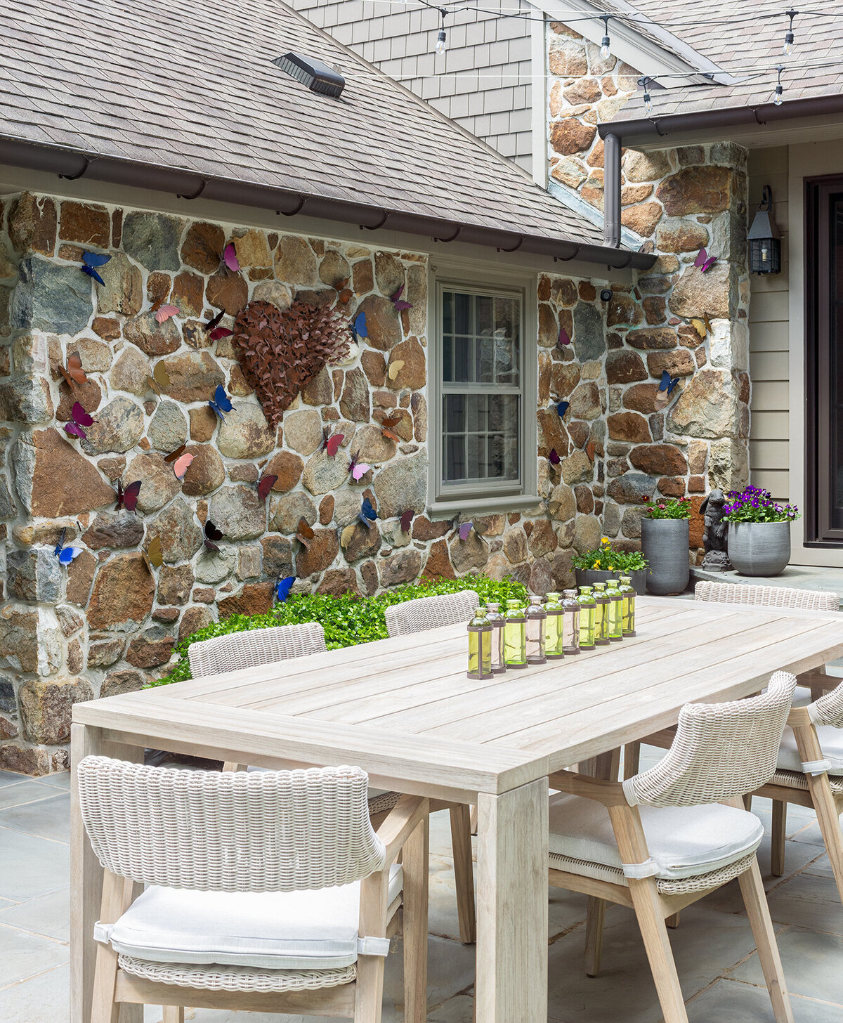 outdoor patio dining set with stone house exterior