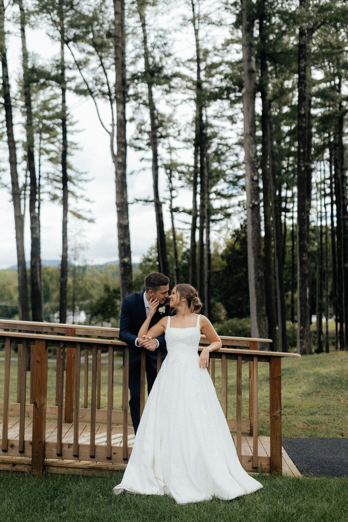 Bride and groom sharing a quiet moment under an umbrella in the Adirondack forest