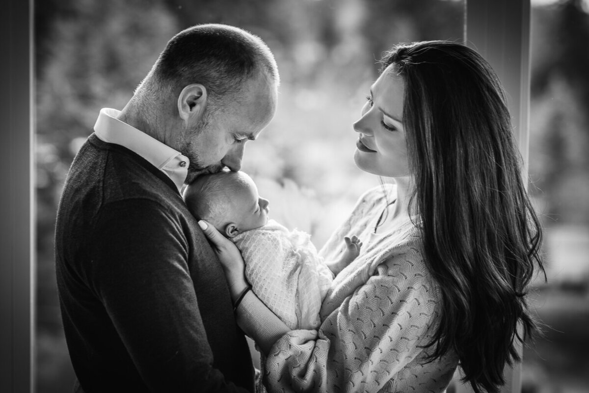 father-kissing-newborn-family-photoshoot-at-home