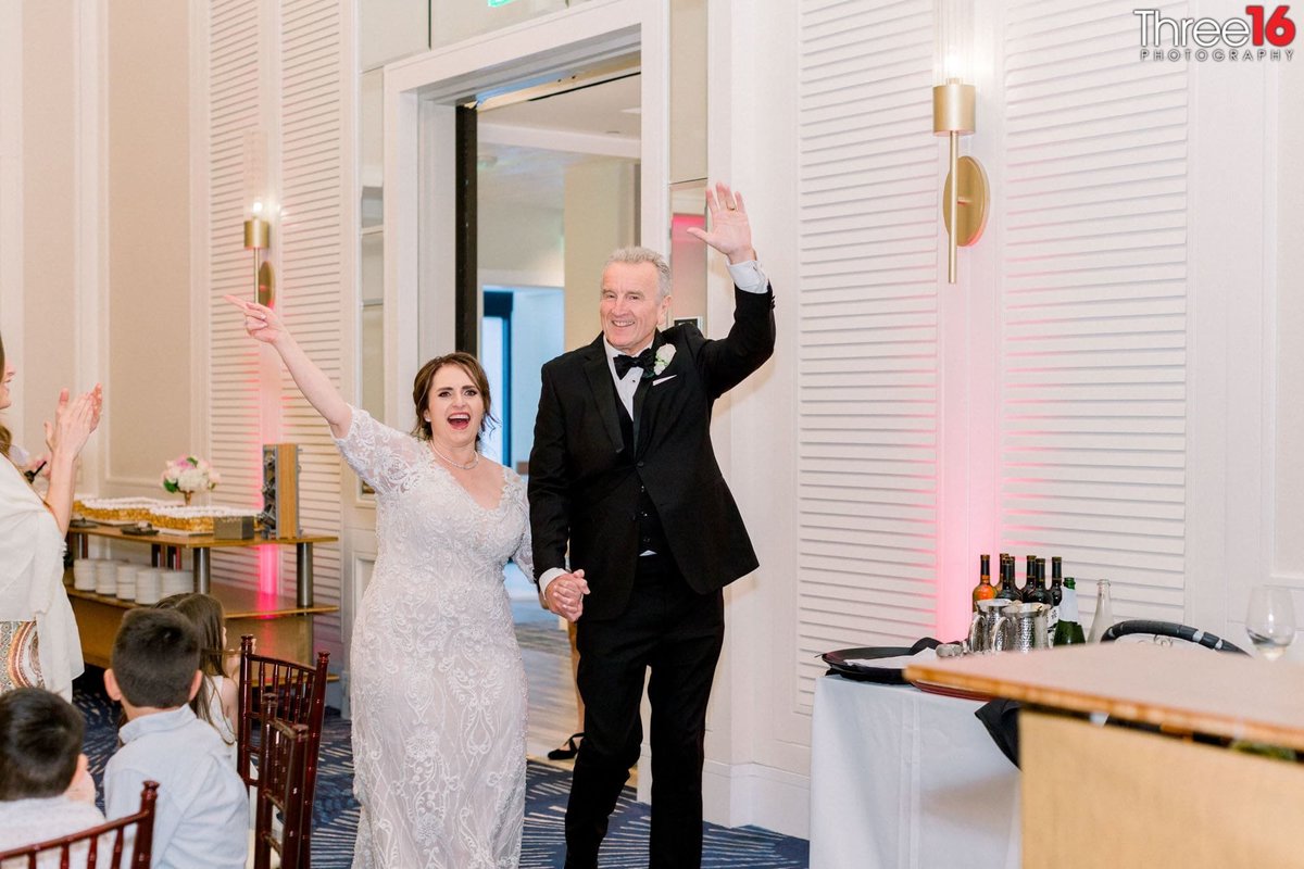 Bride and Groom enter the reception waving to their adoring fans
