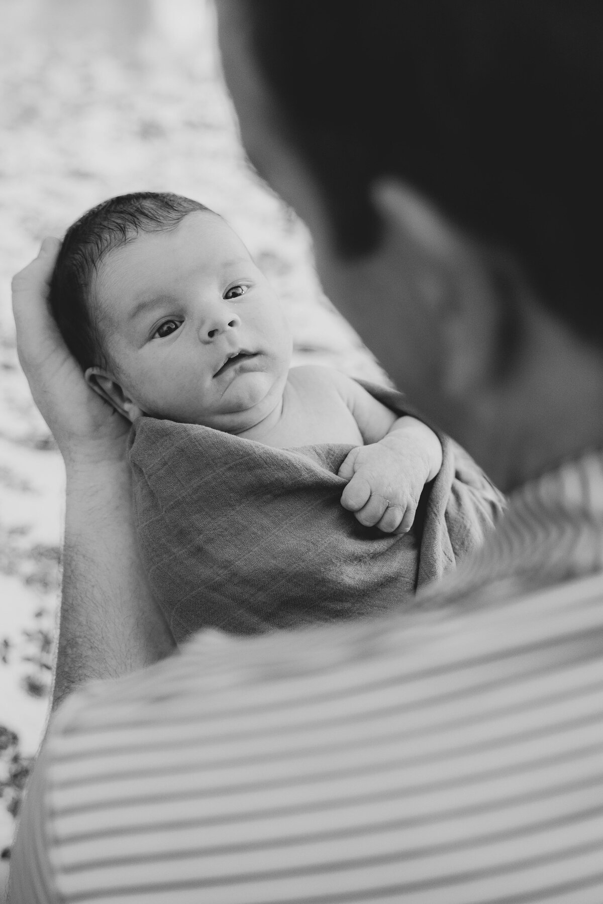 black and white of dad holding newborn baby