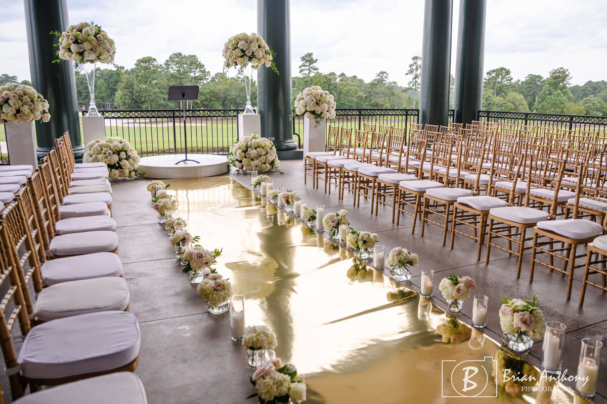 Dreamy aisle view of a beautifully decorated wedding ceremony space with floral arrangements.