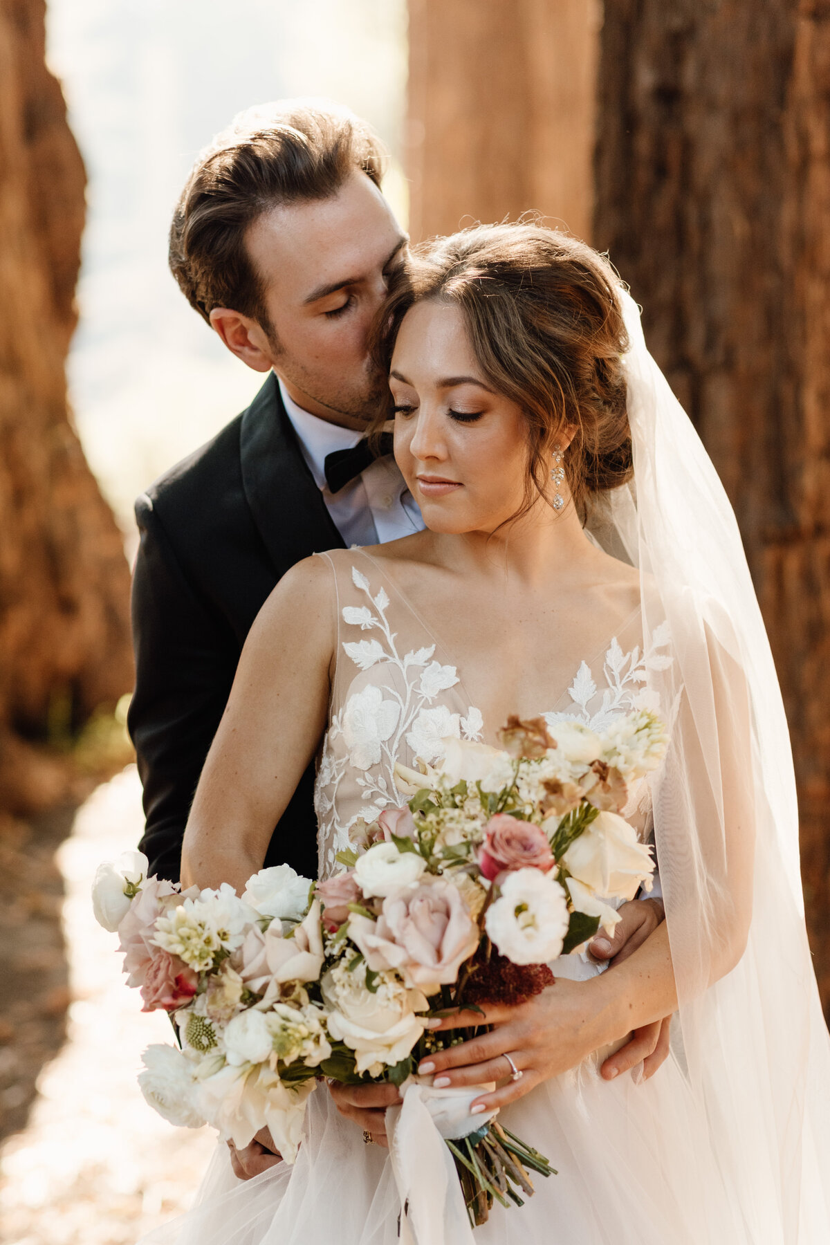 bride and groom hugging with bouquet