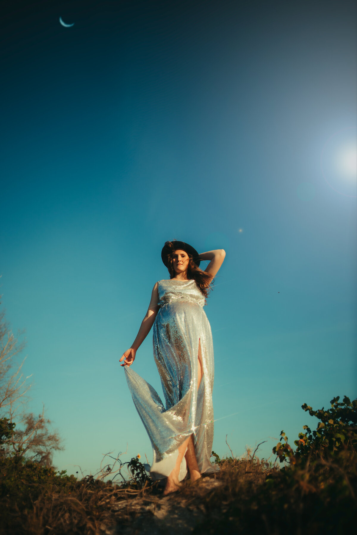 vintage inspired maternity photo session taken at sunset at a beach in st pete fl with a women in a sequin gown