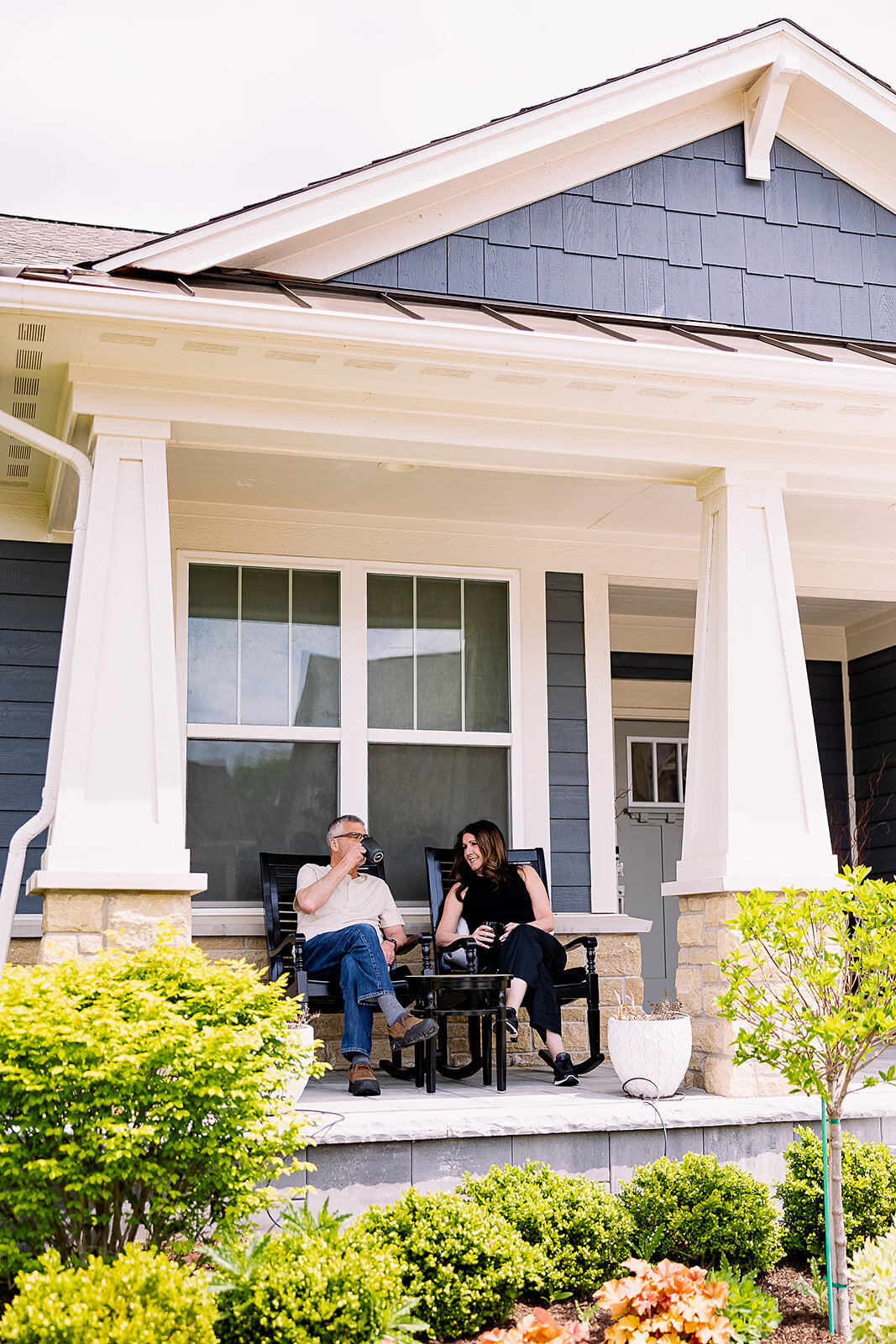 Owners of Arciera Home Care sitting on the porch of a home in rocking chairs talking to each other