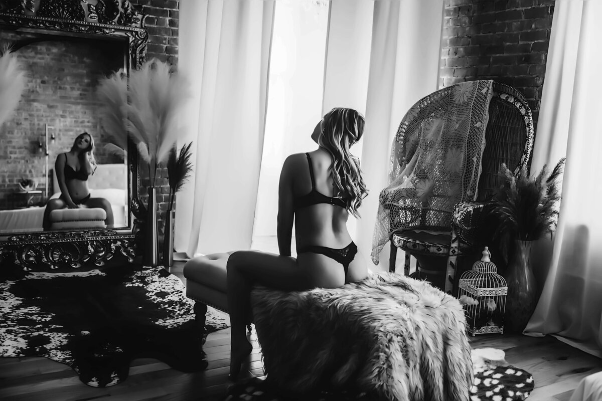 woman sitting on bench in boudoir session with reva davis photography