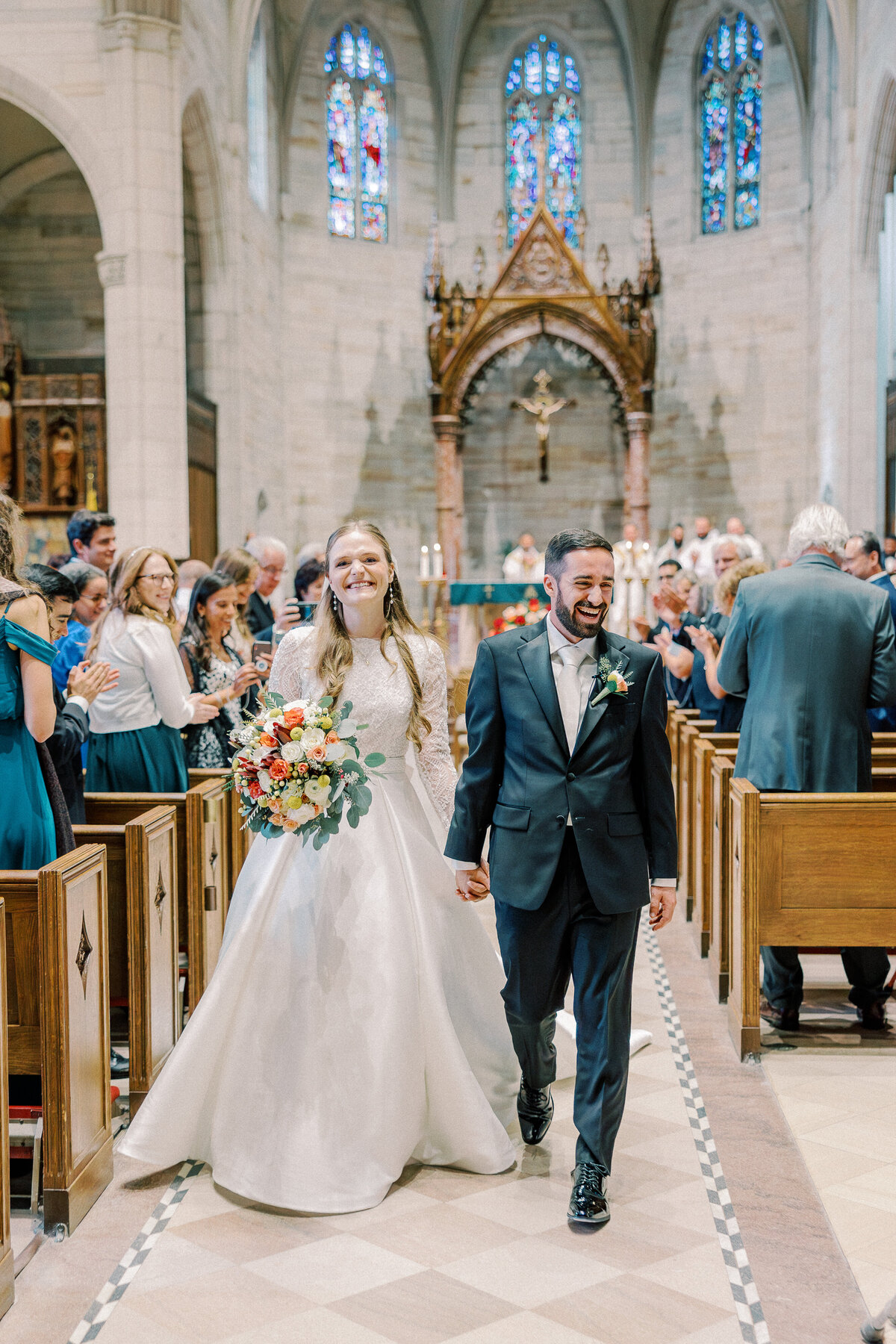 Bride and groom walking up aisle after wedding Mass at Our Lady Sorrows Church
