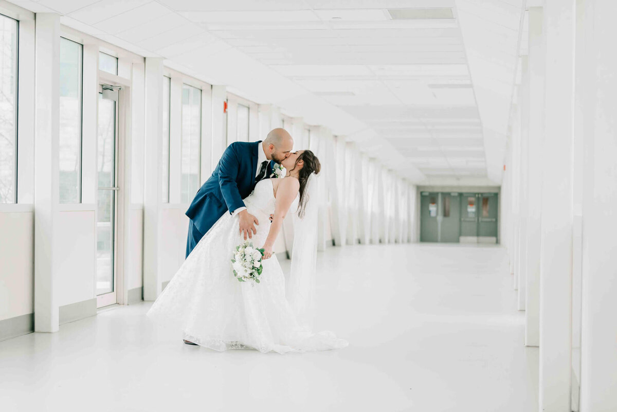 Grrom dips bride slightly and kisses her.