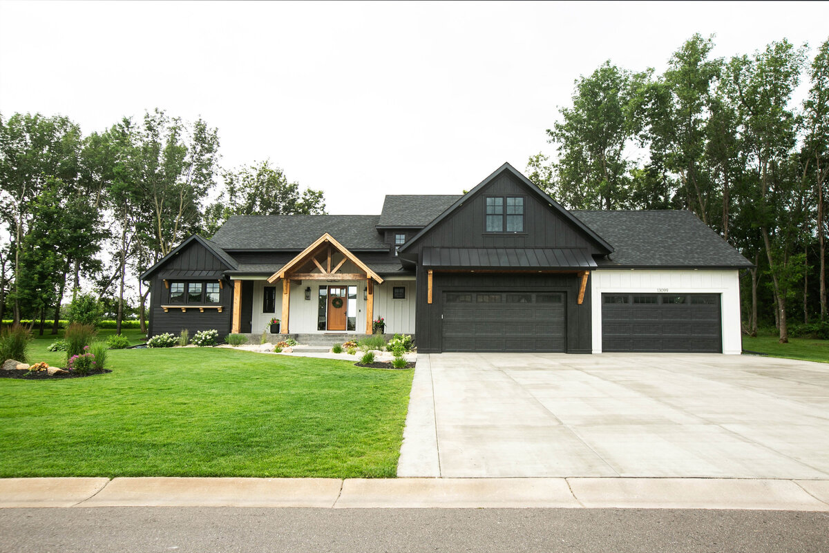 Exterior view of custom home in Otsego, Minnesota with modern wood details and front porch built by Cornerstone Custom Builds
