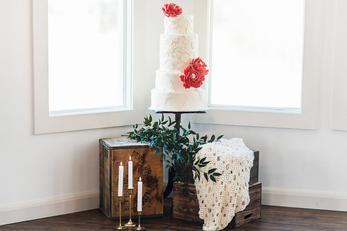 Elegant 4 tiered white wedding cake with beautiful floral and pearl details, topped with pink peonies, by Yvonne's Delightful Cakes, classic cakes & desserts in Calgary, Alberta, featured on the Brontë Bride Vendor Guide.