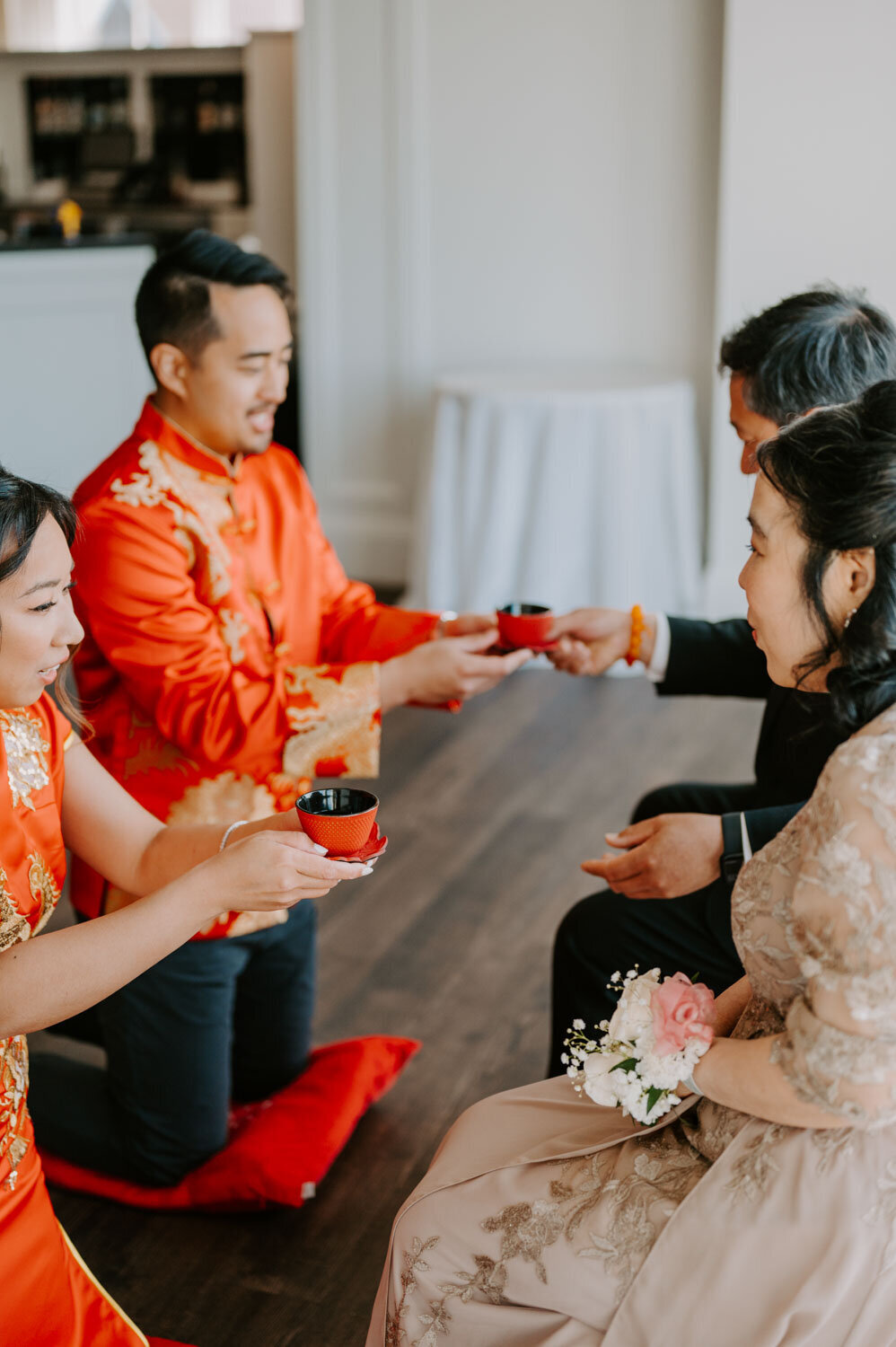 Traditional wedding tea ceremony with the couple kneeling before elders