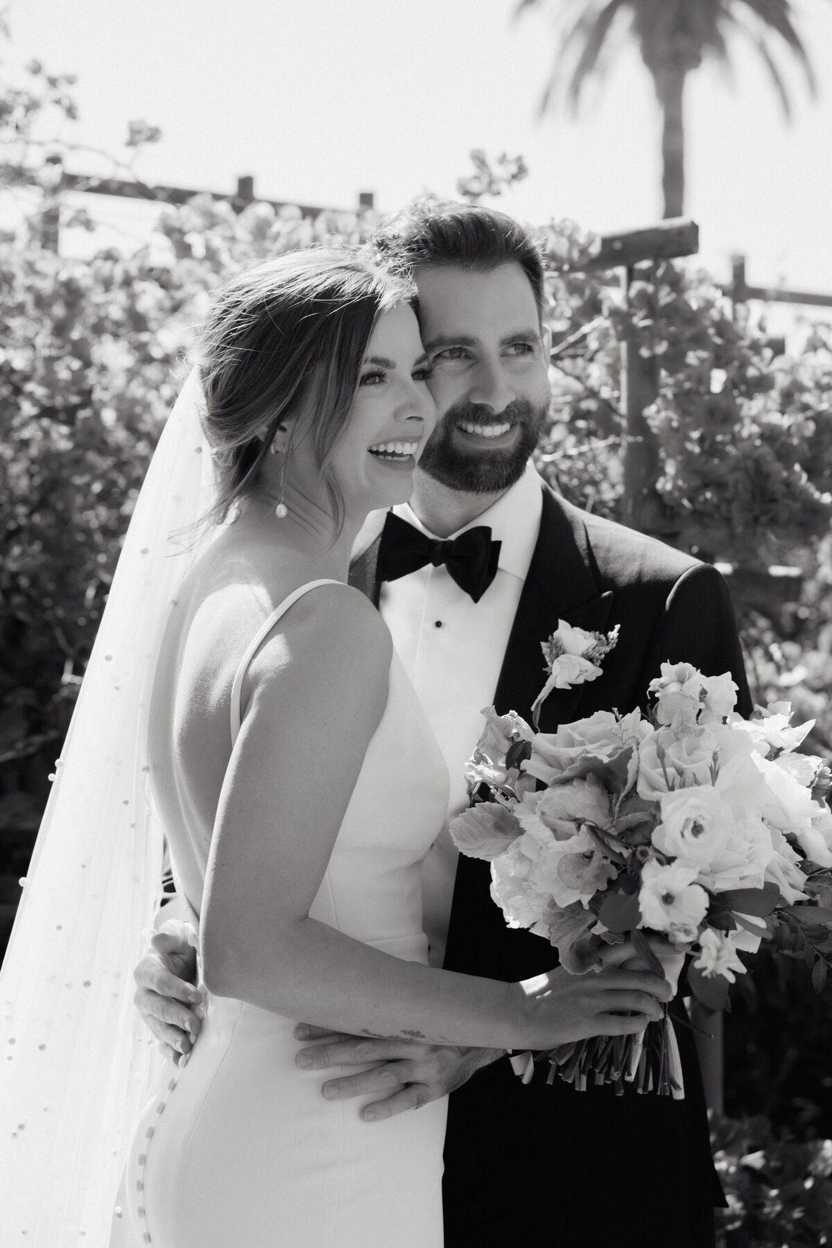 Bride and groom sharing joyful moment, sophisticated portrait captured in cinematic style, La Jolla wedding.