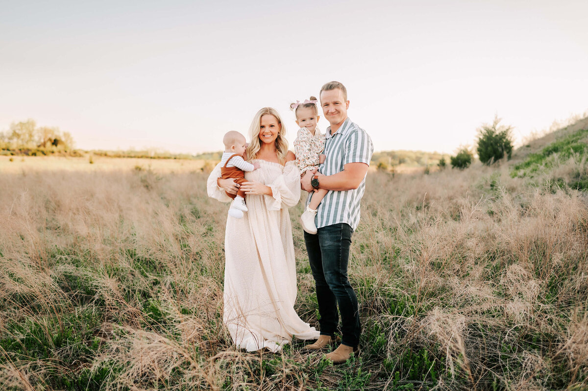 Springfield MO family photographer captures family smiling in field