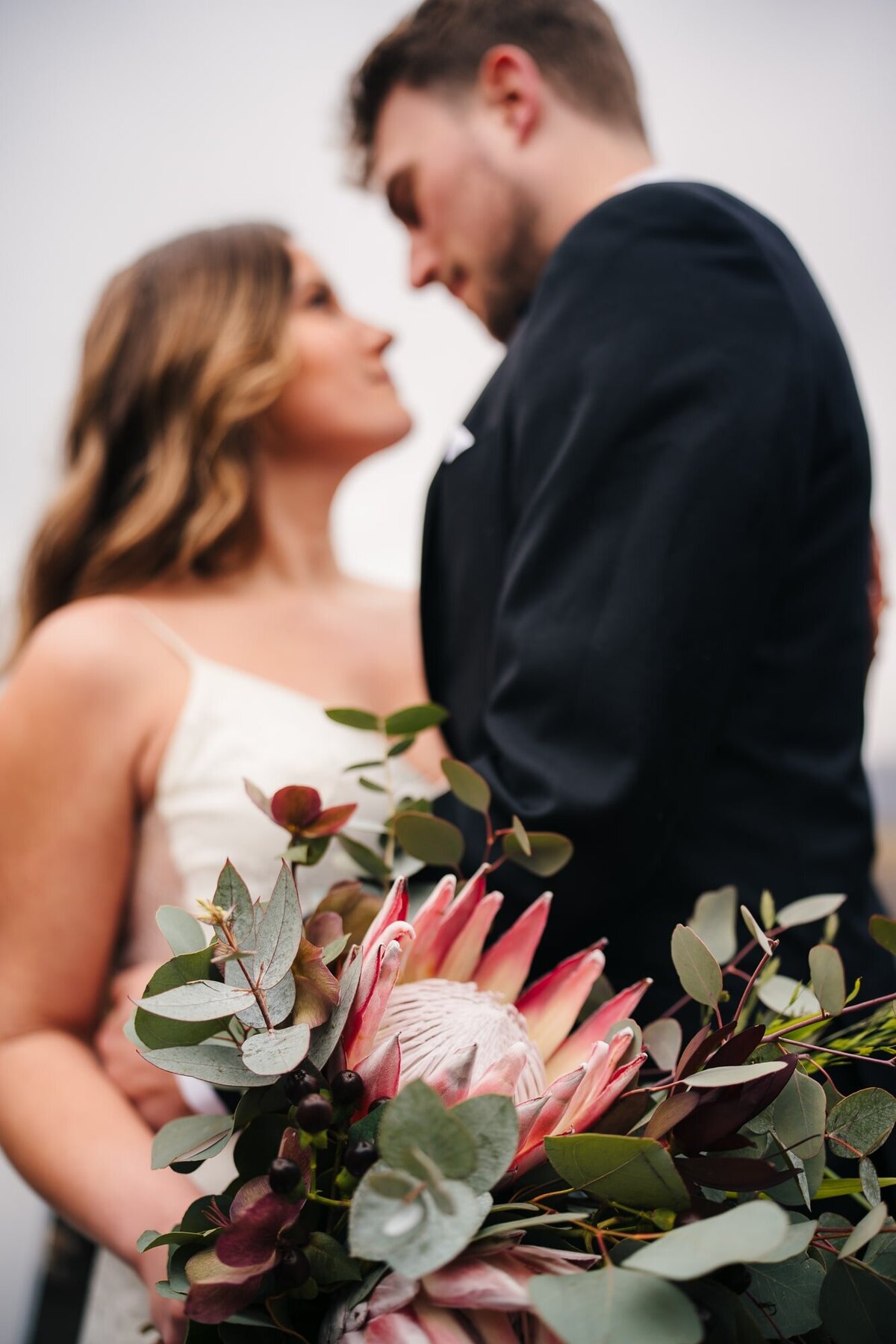 With the couple as a delightful backdrop, the focus shifts to a stunning bouquet of flowers, adding a burst of color and romance to the scene.