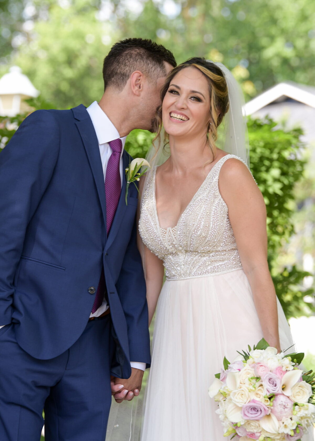 Wedding couple standing in lush greenery