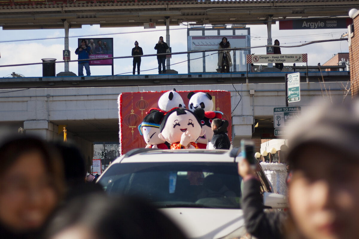 Girl mascot and panda bears riding on top of car in Vietnamese Tet New Year parade